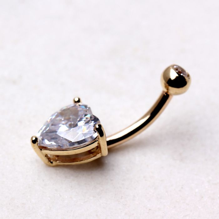 a gold belly button with a diamond in it