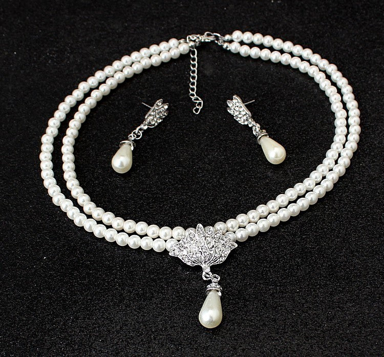 a necklace and earrings on a black surface