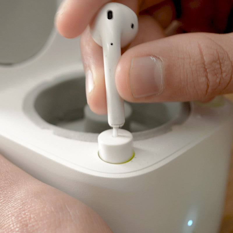 a person holding a white earbuds