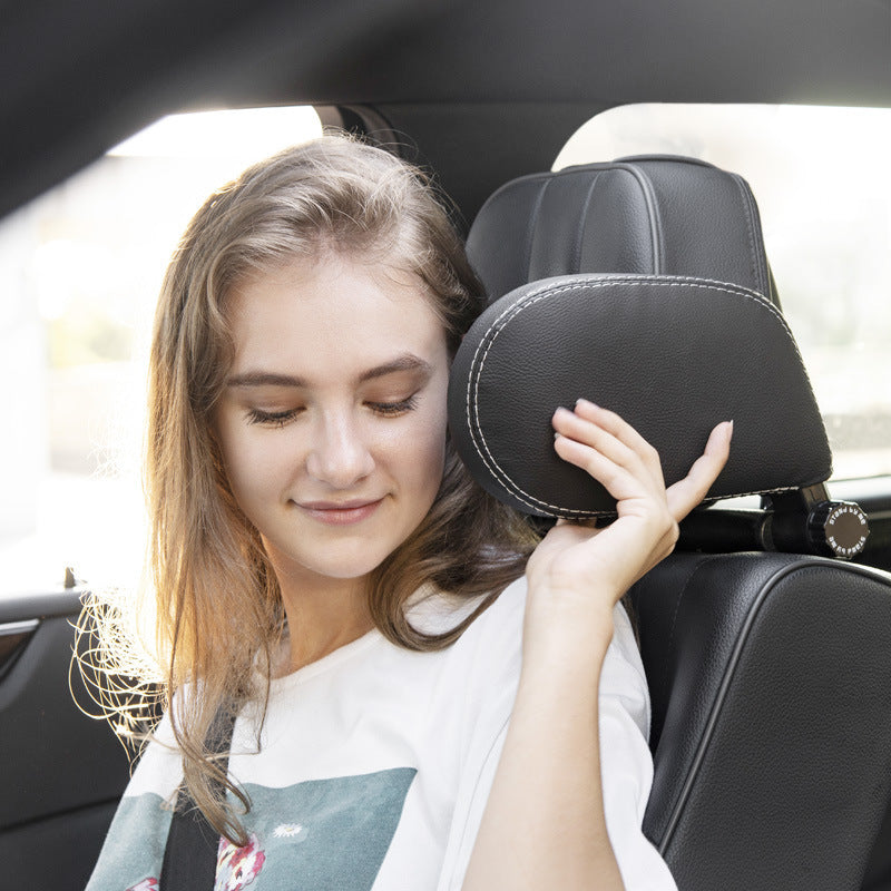 a woman holding a headrest in a car