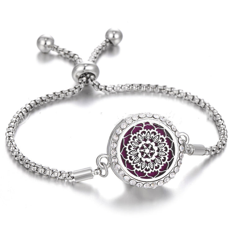 a silver bracelet with a purple medallion