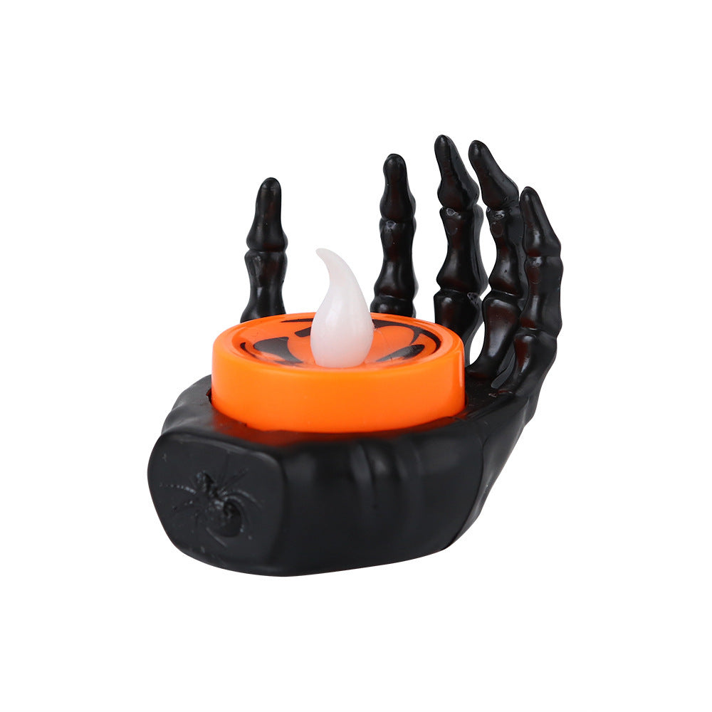 a black and orange candle holder with a spider's hand