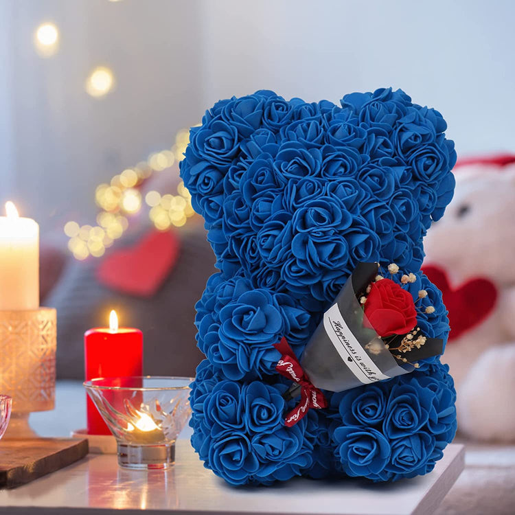 a blue teddy bear with roses and candles