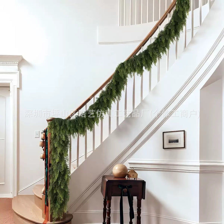 a staircase with a green garland on the side of the stairs
