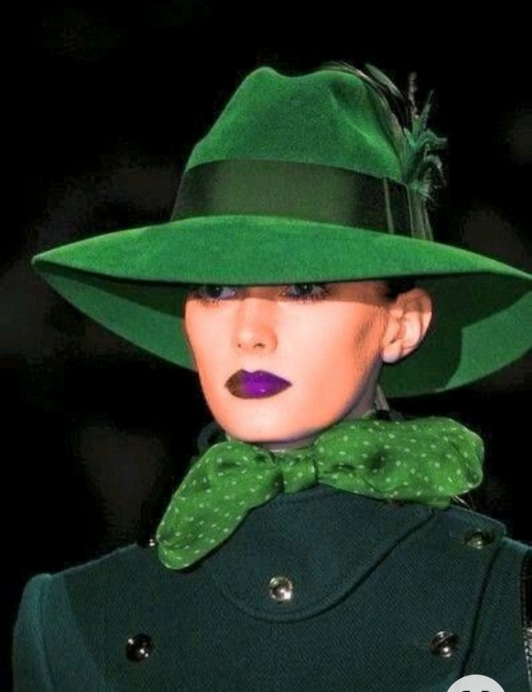 a woman wearing a green hat and a bow tie
