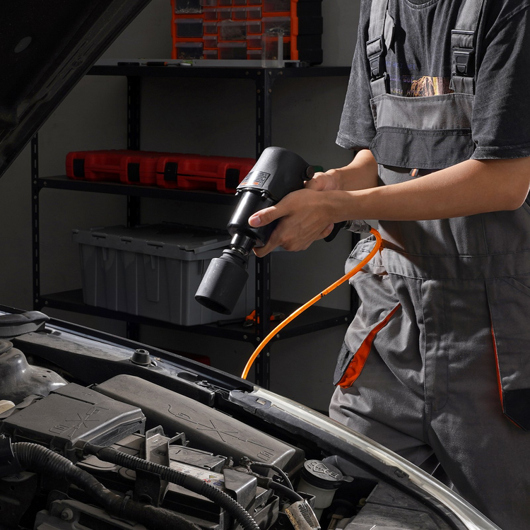 a man holding a drill in a garage