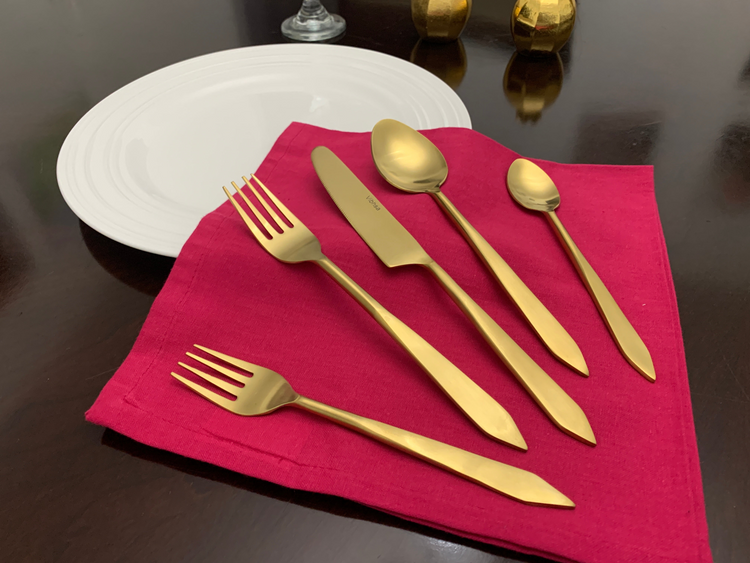 a gold cutlery on a napkin
