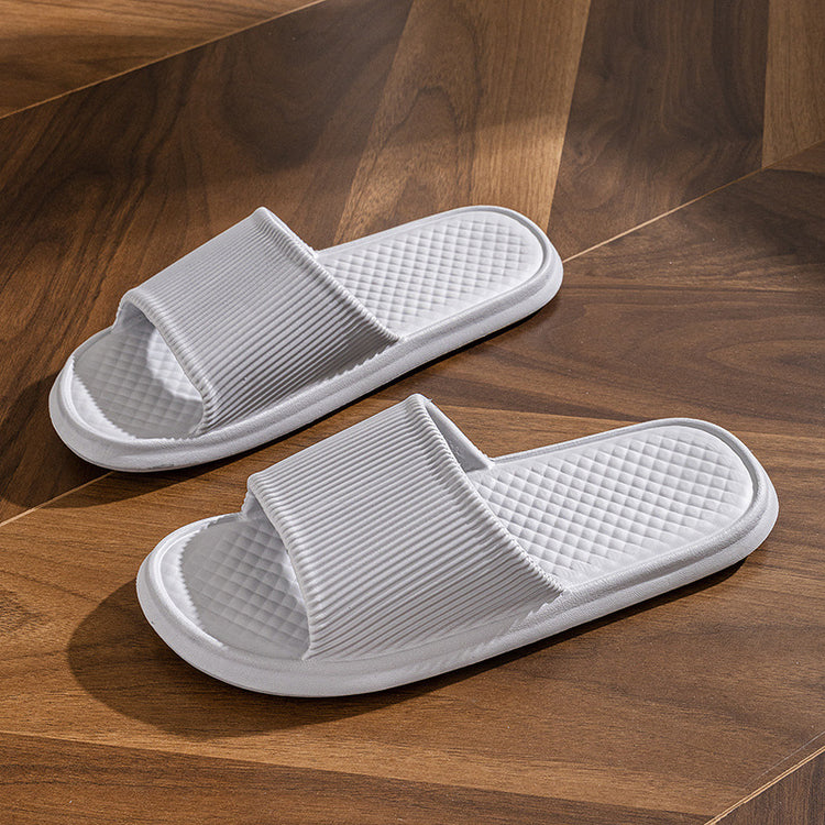 a pair of white slippers on a wood floor