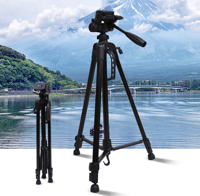 a camera on a tripod next to a body of water