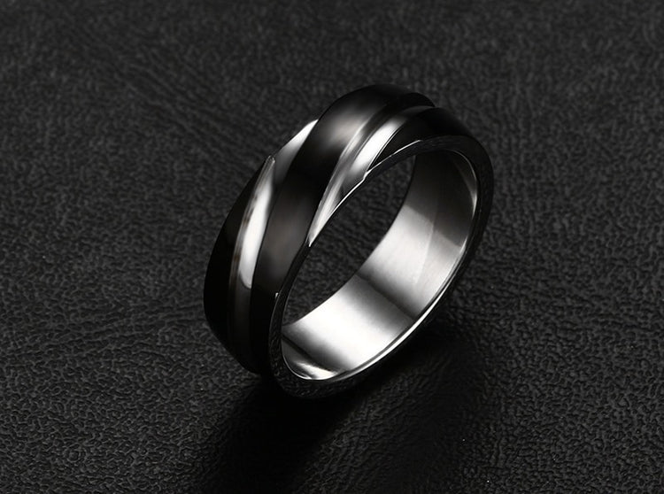 a silver ring on a black surface