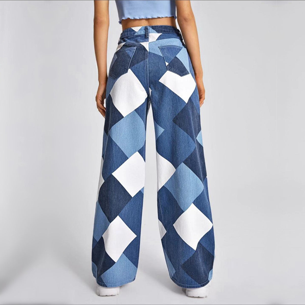 a woman wearing a pair of blue and white checkered jeans