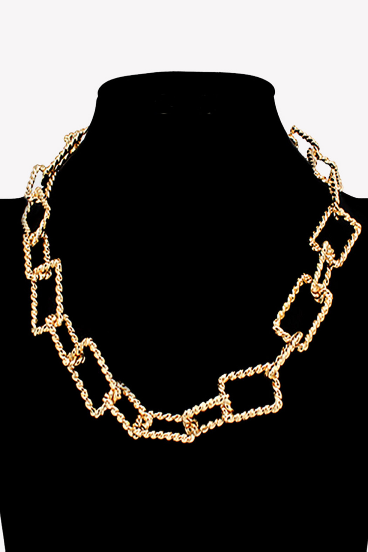 a gold chain necklace on a mannequin