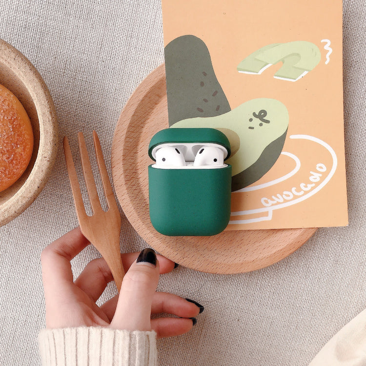 a hand holding a fork and a green case