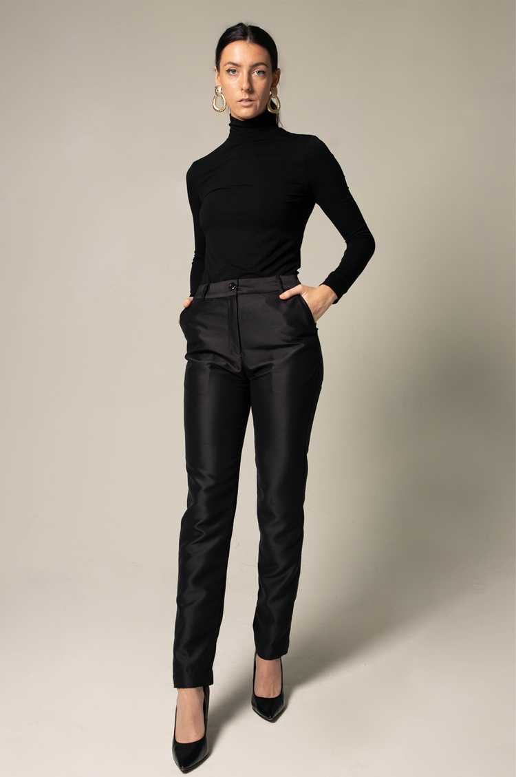 a woman in black turtleneck and black pants