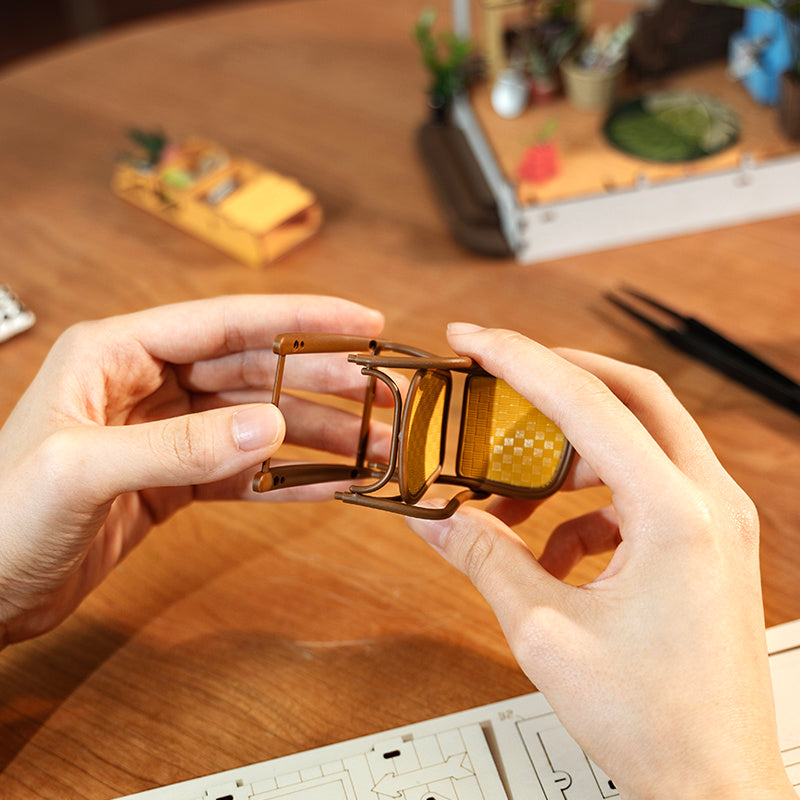 hands holding a small model of a toy