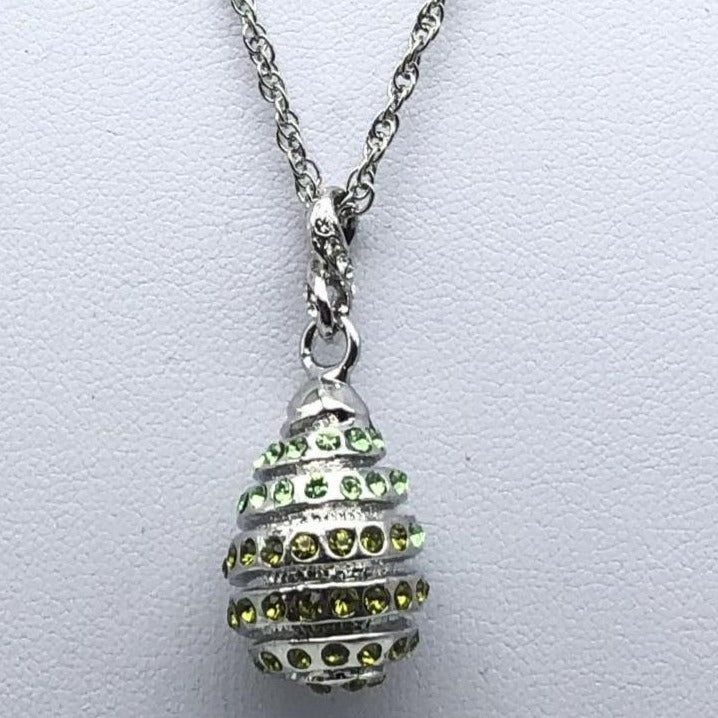 a silver necklace with green stones