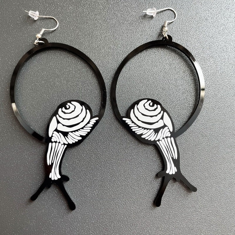 a pair of earrings on a gray surface