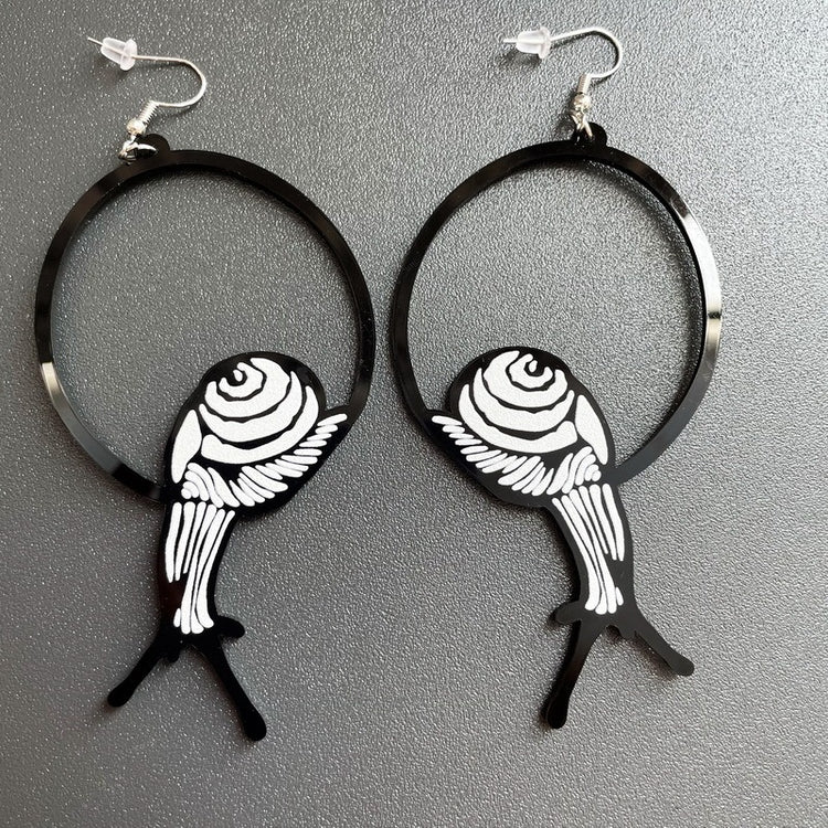 a pair of earrings on a gray surface