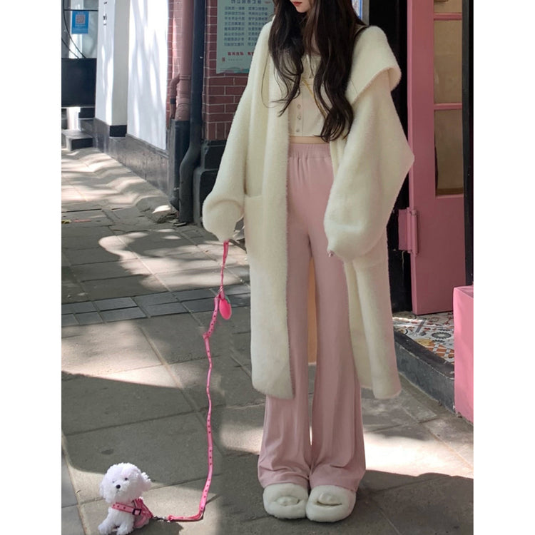 a woman wearing a white coat and pink pants