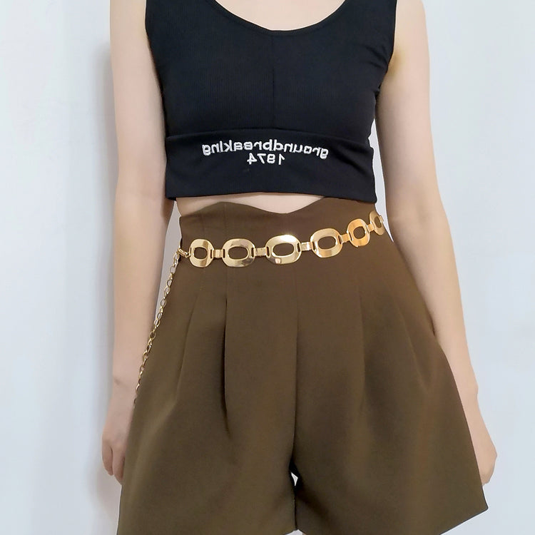 a woman wearing a black tank top and brown shorts