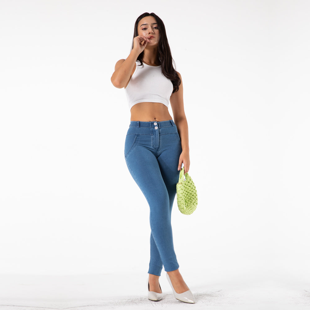 a woman in blue jeans and white top holding a green bag