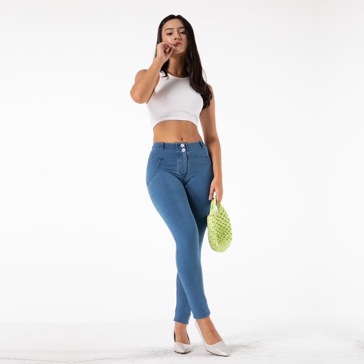 a woman in blue jeans and white top holding a green bag