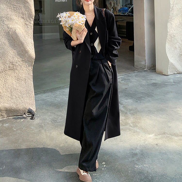 a woman in a black coat holding a bouquet of flowers