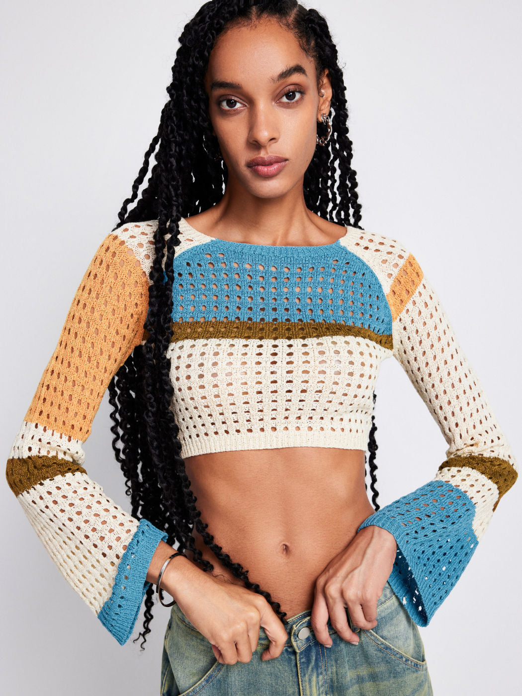 a woman with long black hair wearing a knit sweater