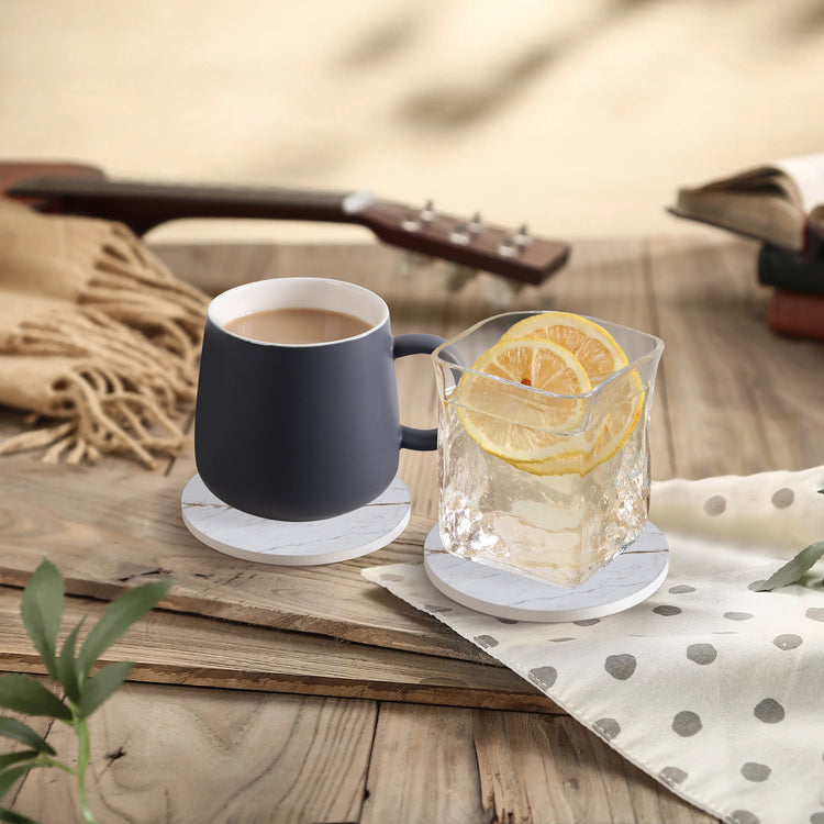 a cup of coffee and a glass of ice cube with a lemon wedge