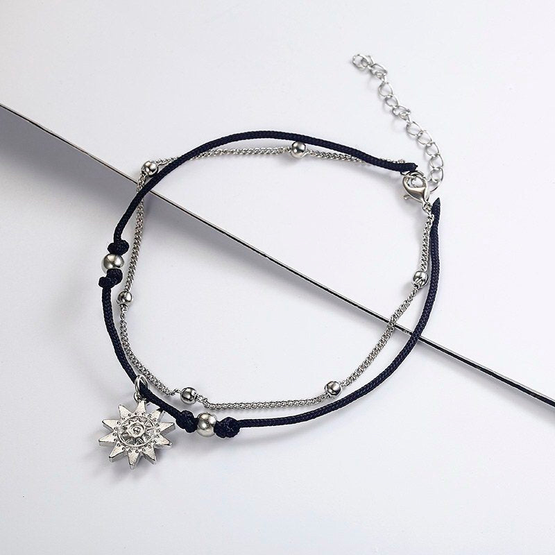 a black and silver bracelet with a silver charm