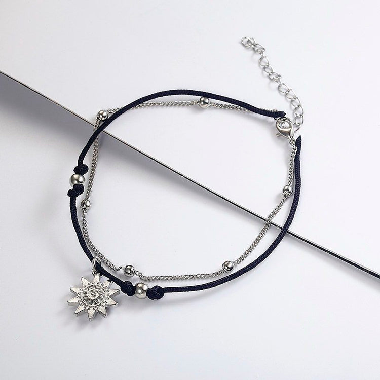 a black and silver bracelet with a silver charm