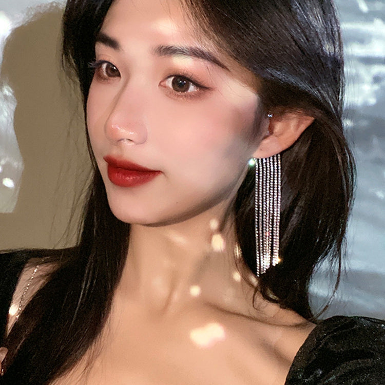 a woman with long hair wearing earrings