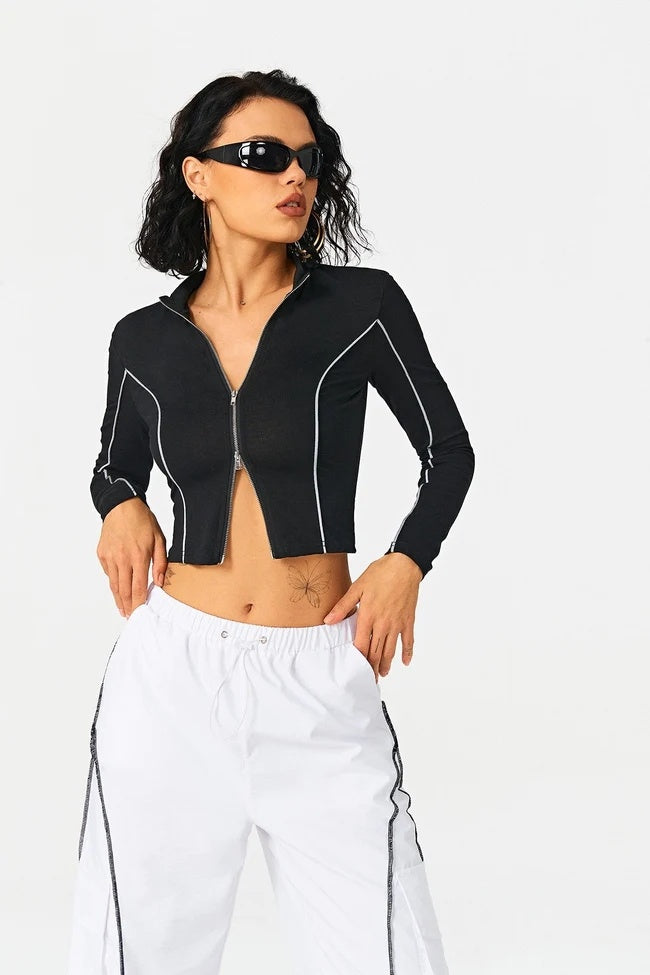 a woman in a black jacket and white shorts