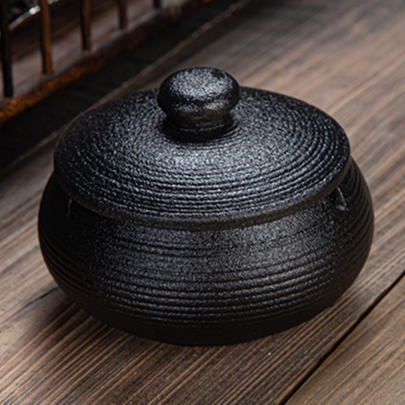 a black round container with a lid