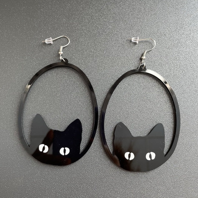 a pair of earrings with cat faces