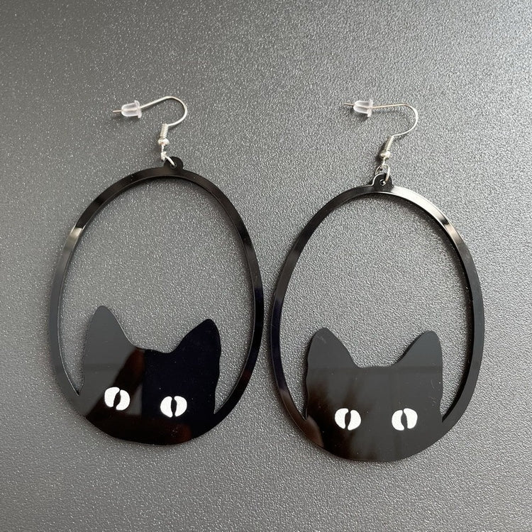 a pair of earrings with cat faces