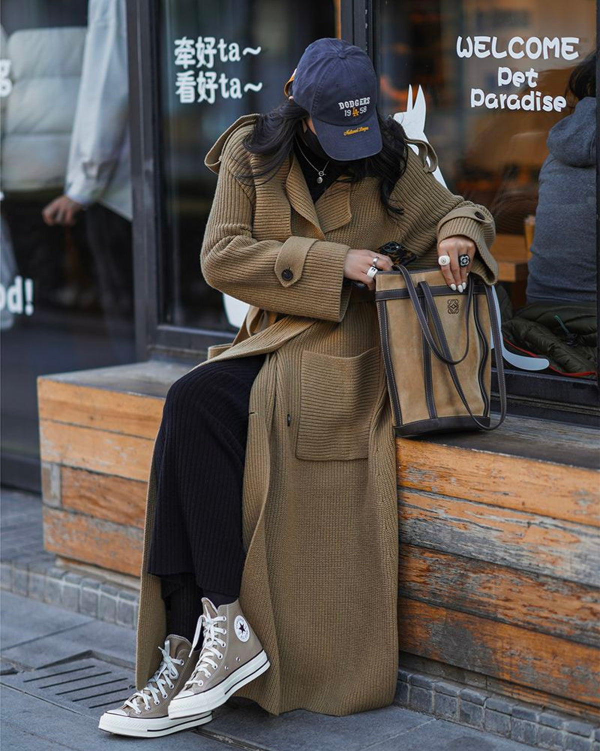 a woman wearing a hat and a long coat