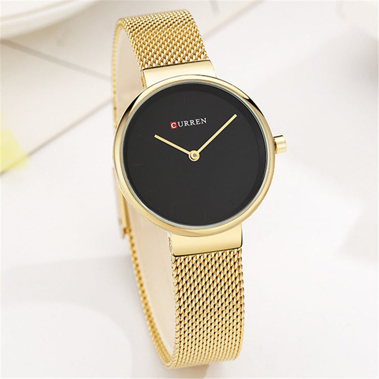 a gold watch with a black face