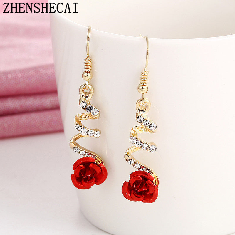 a pair of earrings with a rose on them