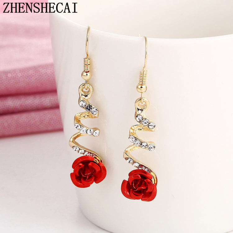 a pair of earrings with a rose on them