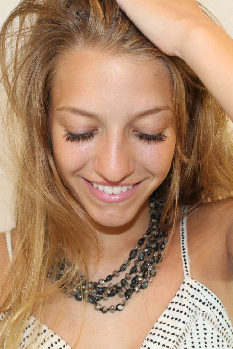 a woman with long blonde hair and a necklace