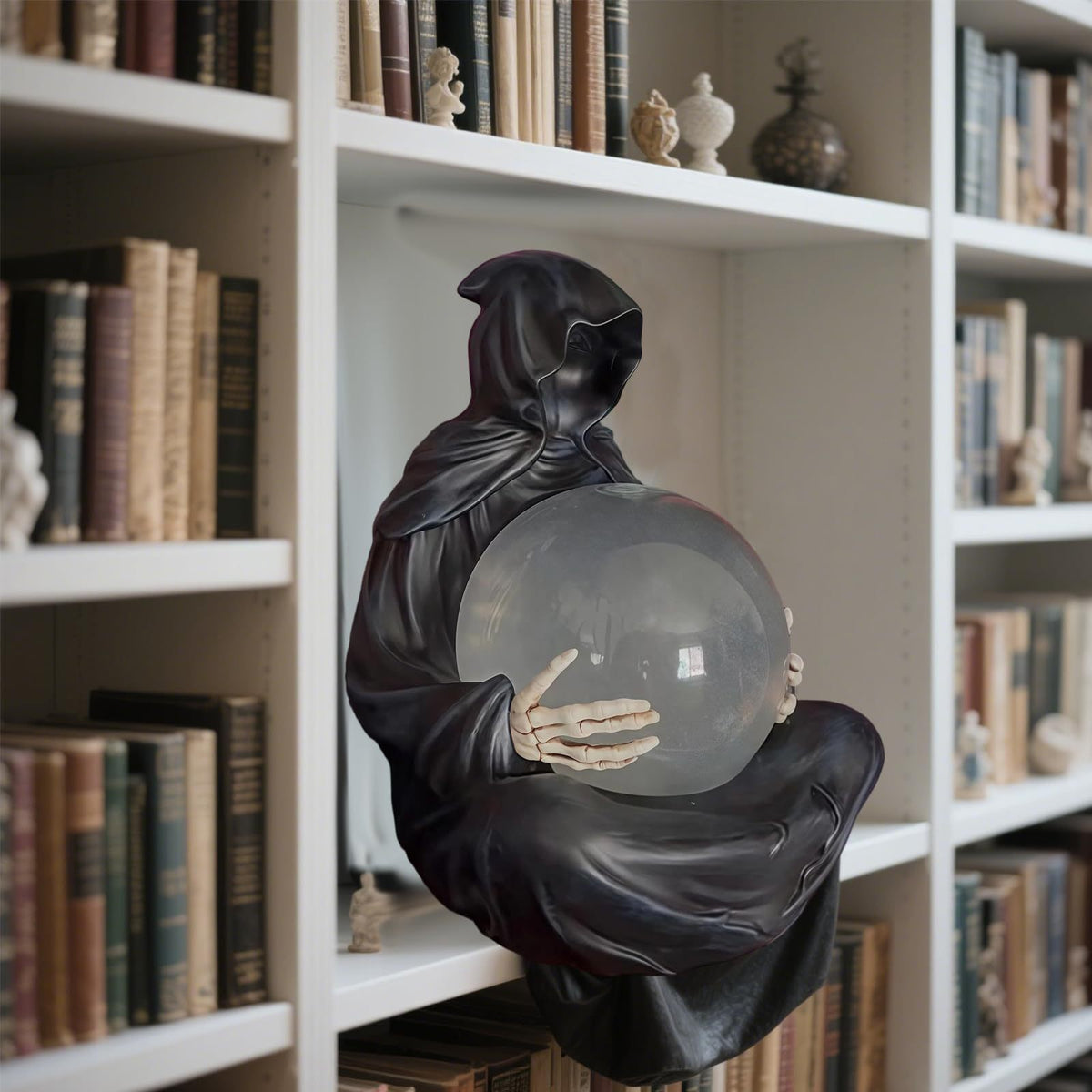 a statue of a person holding a crystal ball on a shelf of books