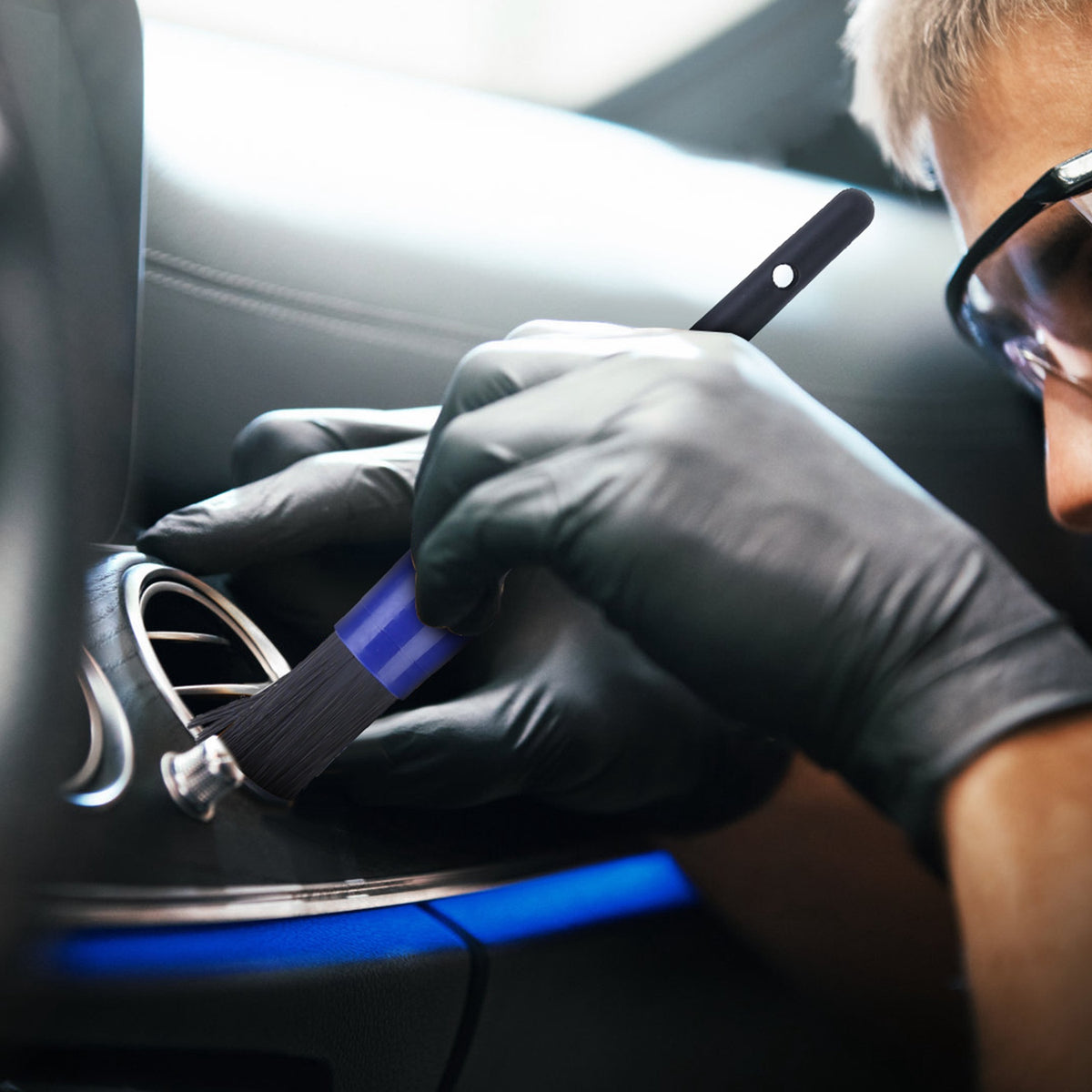 a person cleaning a car air vent