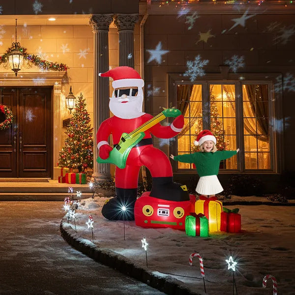 a girl standing in front of a house with a inflatable santa and a guitar