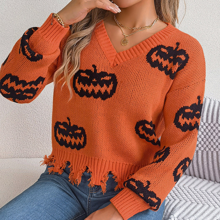 a woman wearing an orange and black sweater with pumpkins on it