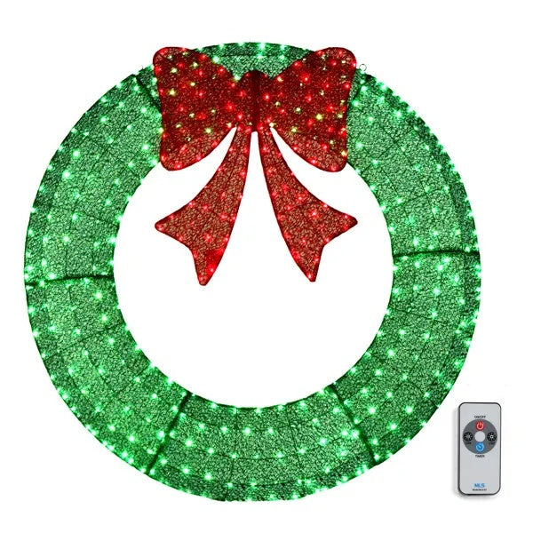 a green and red christmas wreath with a red bow and a remote