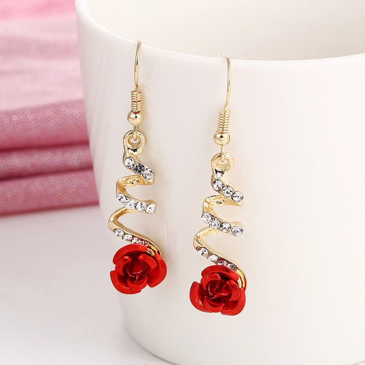 a pair of earrings with red flowers