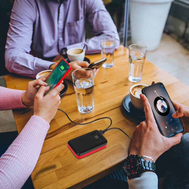 a group of people sitting at a table with cell phones