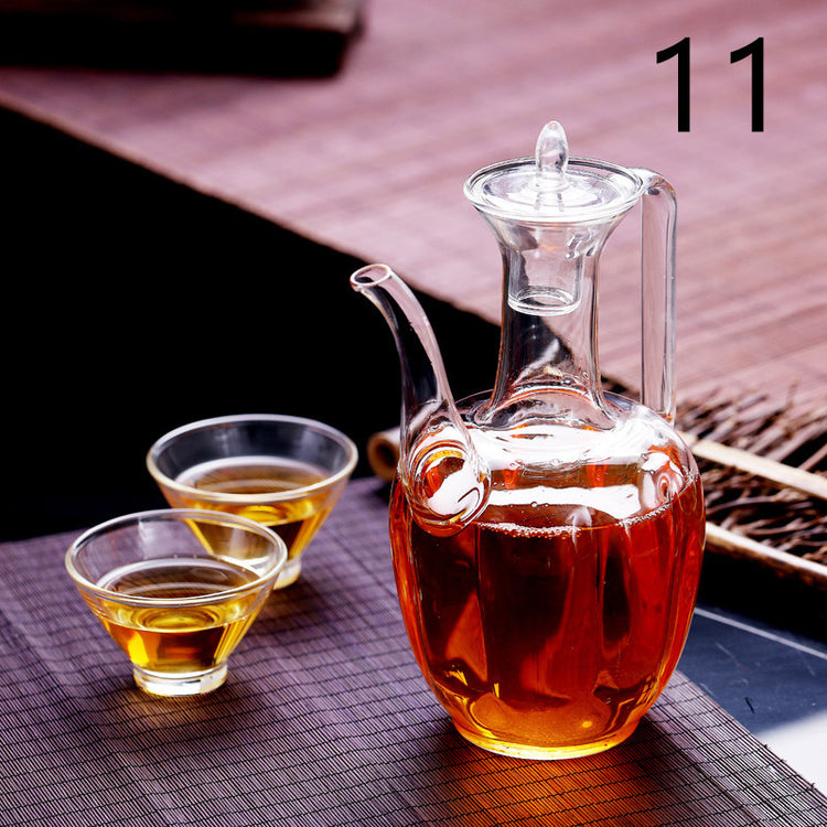 a glass jug with brown liquid next to small cups of liquid