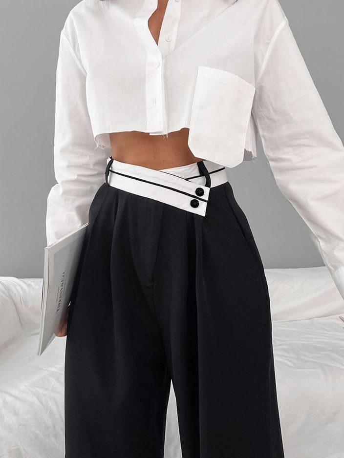a woman wearing a white shirt and black pants